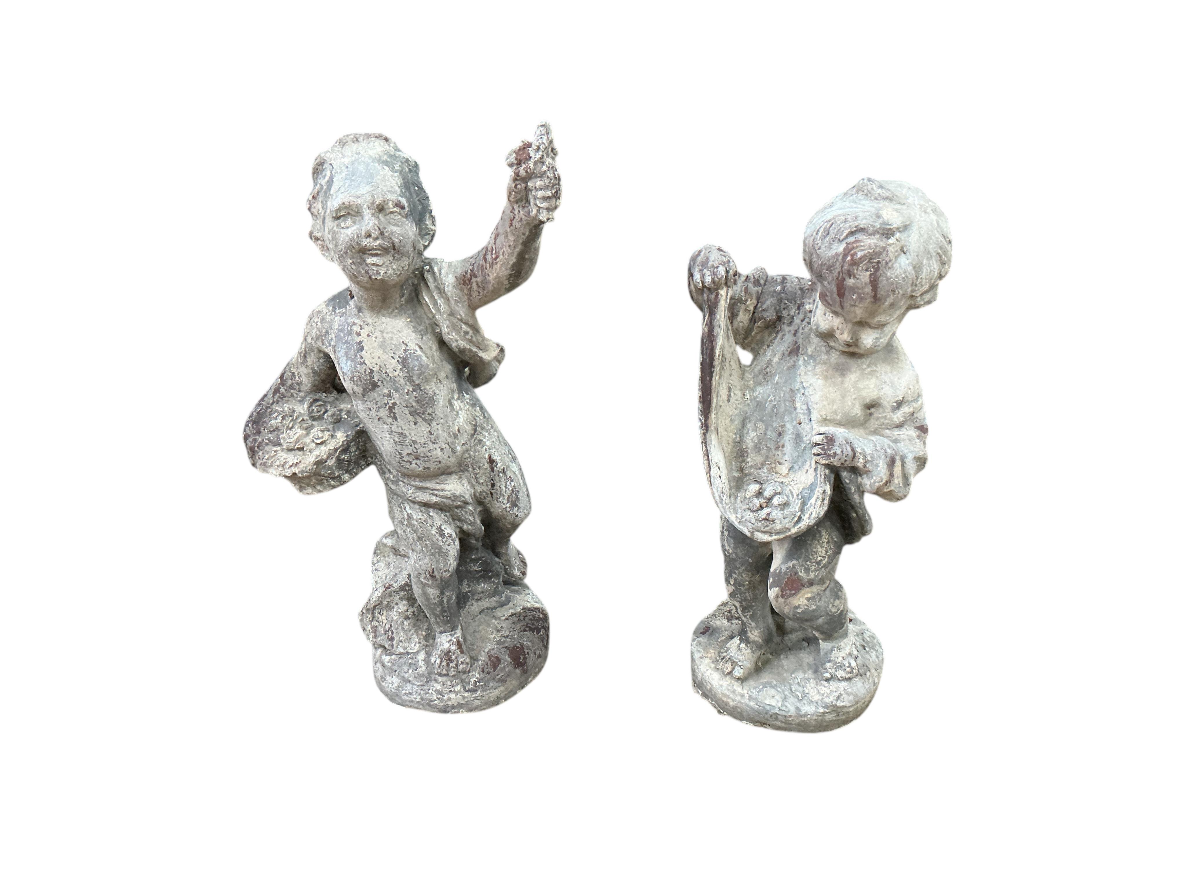 A pair of Victorian lead putti garden ornaments, larger height 48cm